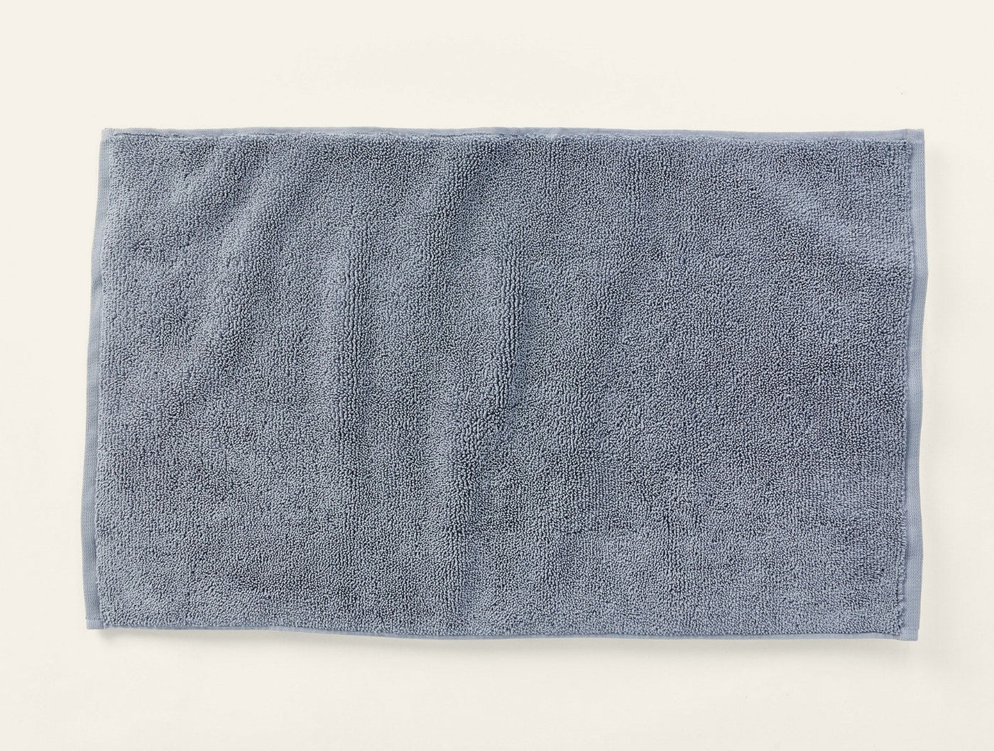 Coyuchi Cloud Loom bath rug in slate blue-grey, flat lay showing plush terry texture.