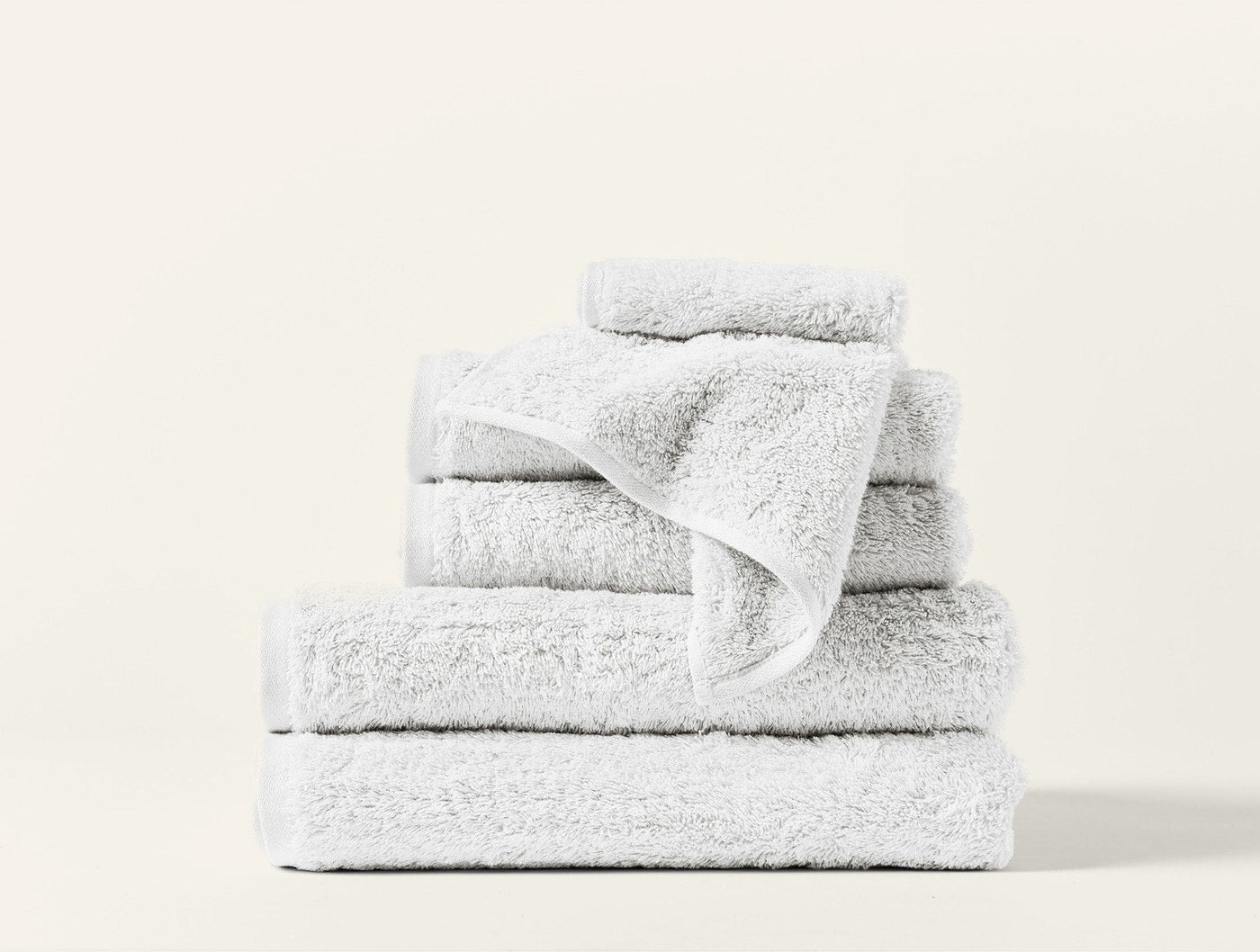 Coyuchi Cloud Loom hand towel in white, stacked set of plush terry towels.