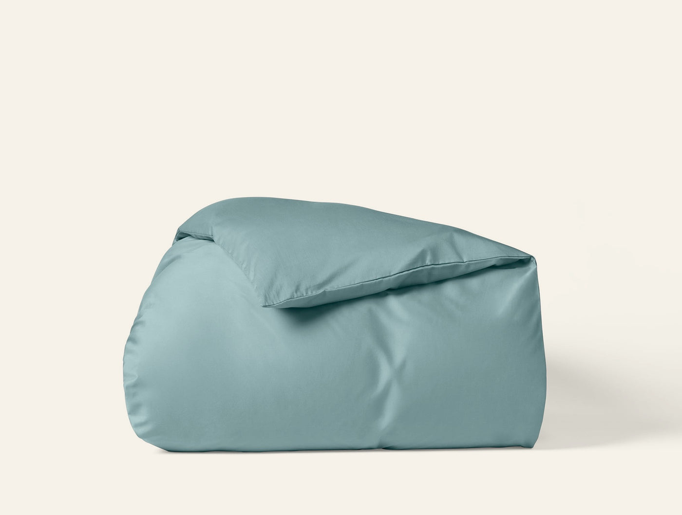 Coyuchi Cloud Soft Sateen duvet cover folded upright, muted teal, smooth sateen finish.