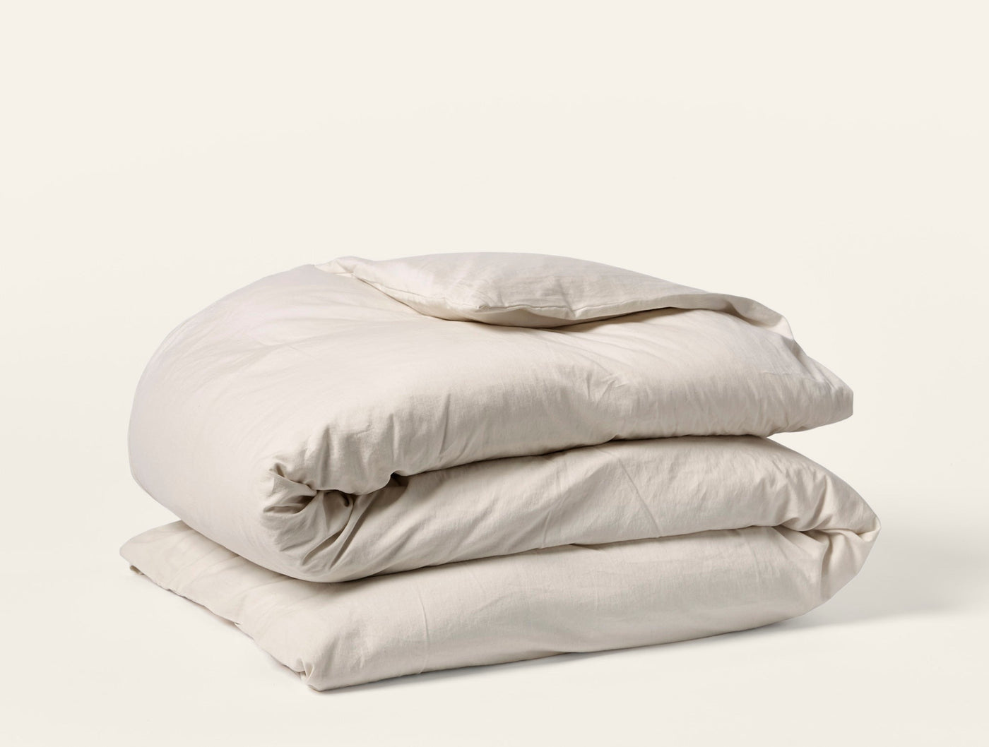Coyuchi Cloud Soft Sateen duvet cover folded in parchment, showing smooth sateen finish.