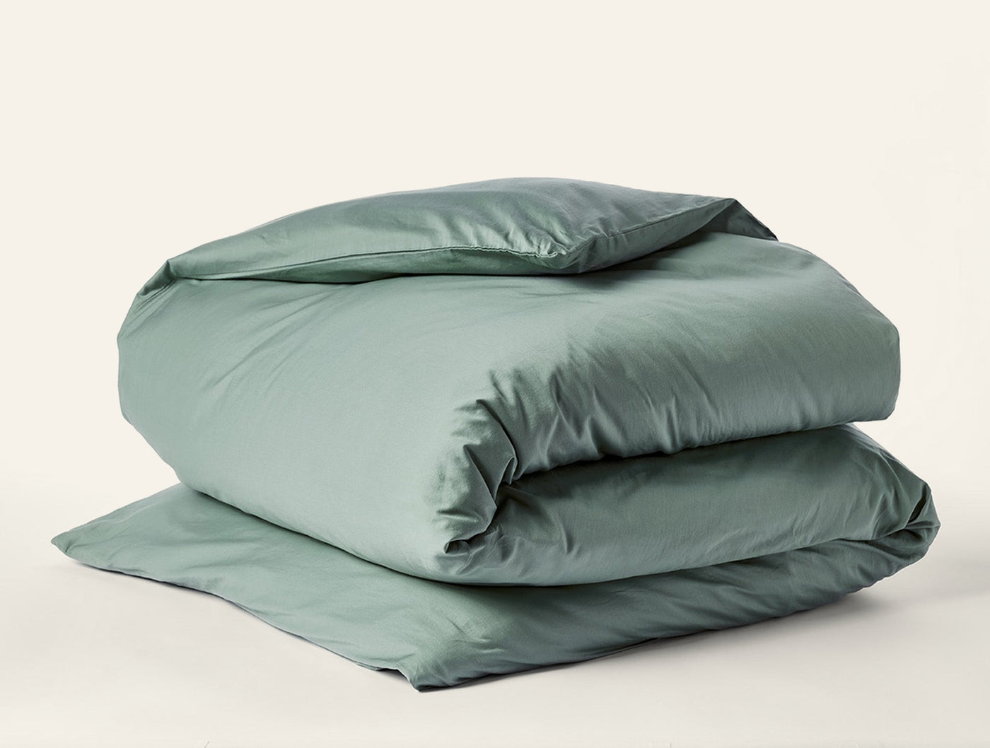 Coyuchi Cloud Soft Sateen duvet cover folded neatly, sage green sateen finish.