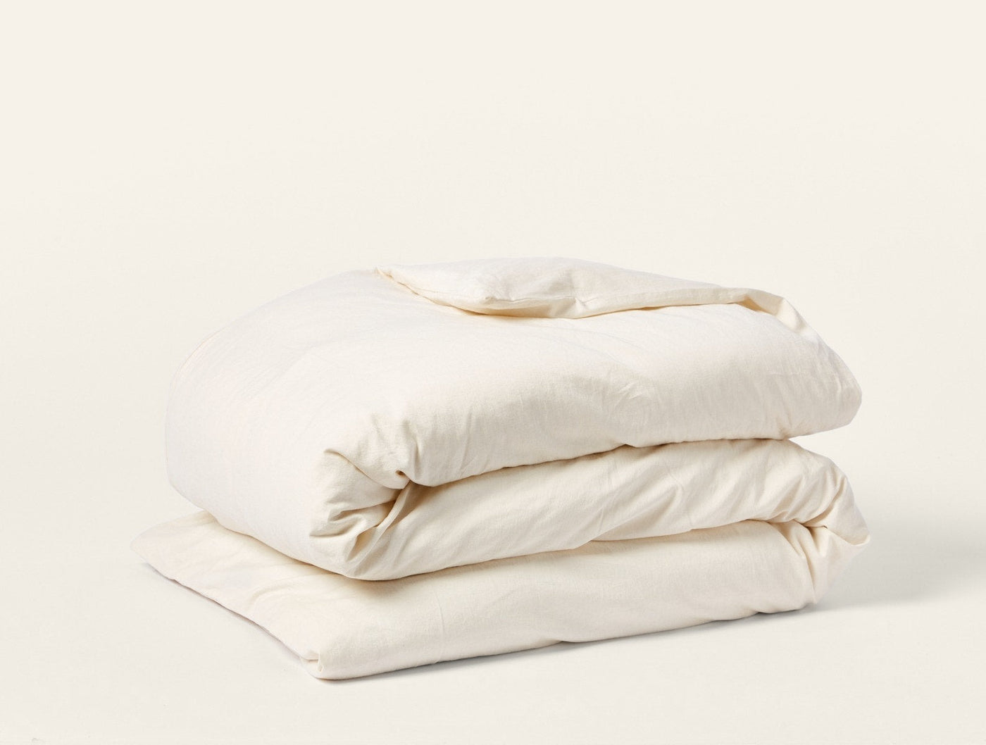 Coyuchi Cloud Soft Sateen duvet cover folded, ivory sateen finish, side angle view.