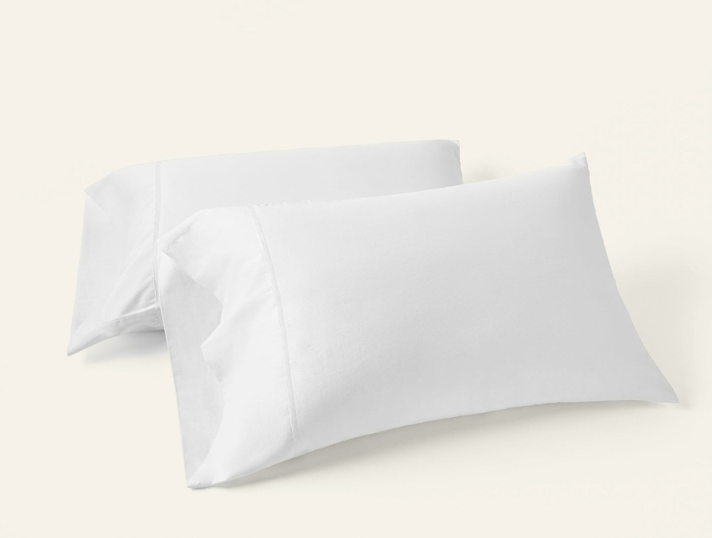 Two white Coyuchi Cloud Soft Sateen pillowcases stacked, showing crisp envelope closure detail.