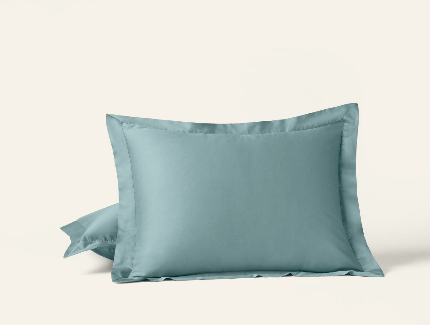 Two Coyuchi Cloud Soft Sateen pillowcases in sea green with tailored flange border.