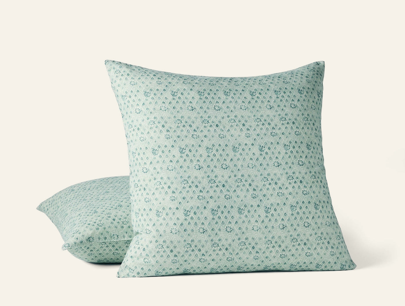 Coyuchi Coral Bell Print pillow covers in sage green, small floral dot pattern, two sizes shown.