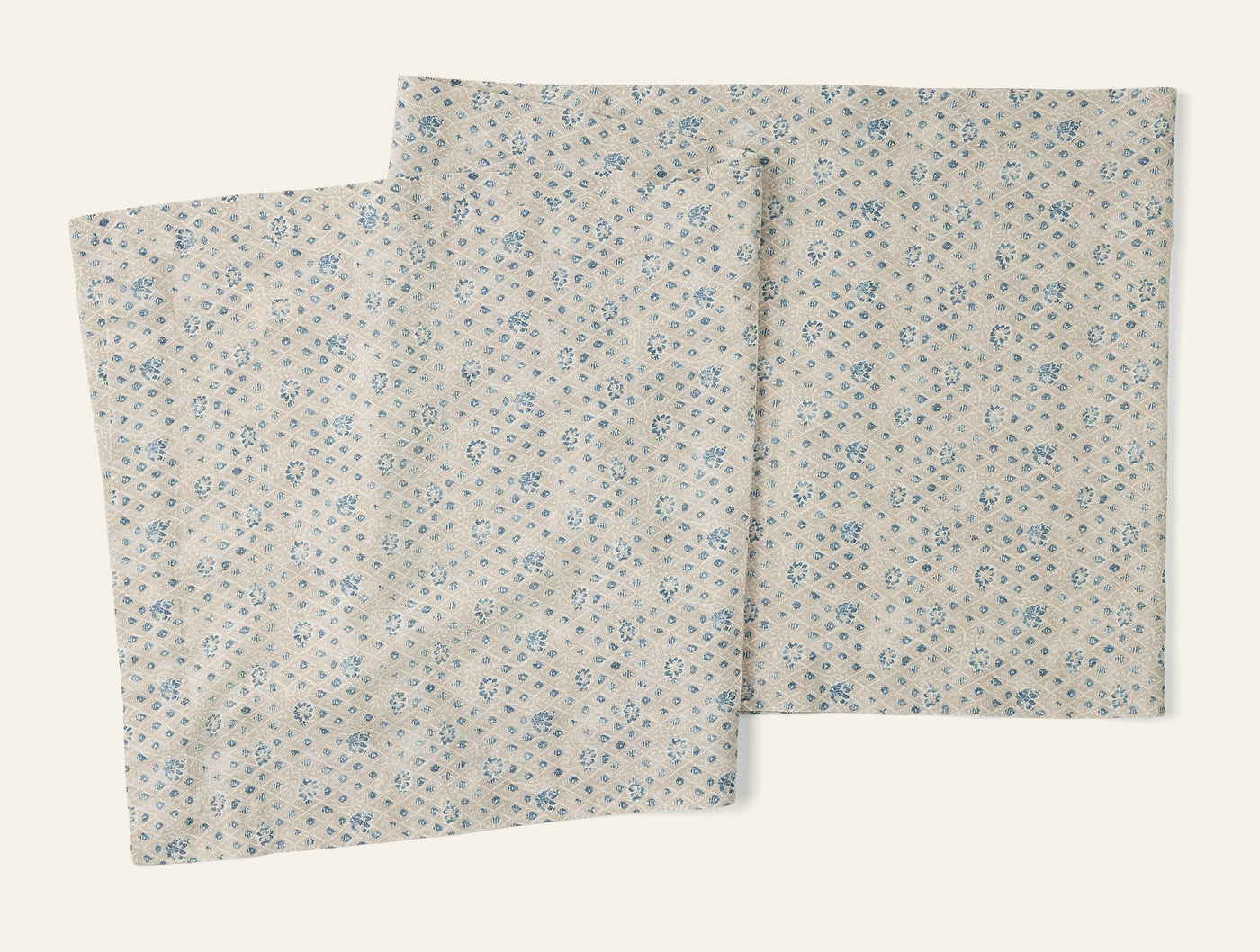 Coyuchi Coral Bell Print table runner in ivory with scattered blue floral pattern, two runners shown.