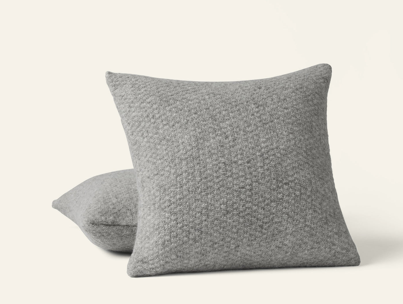 Close-up of two Coyuchi Cordillera pillows in grey alpaca-cotton knit with textured weave pattern.