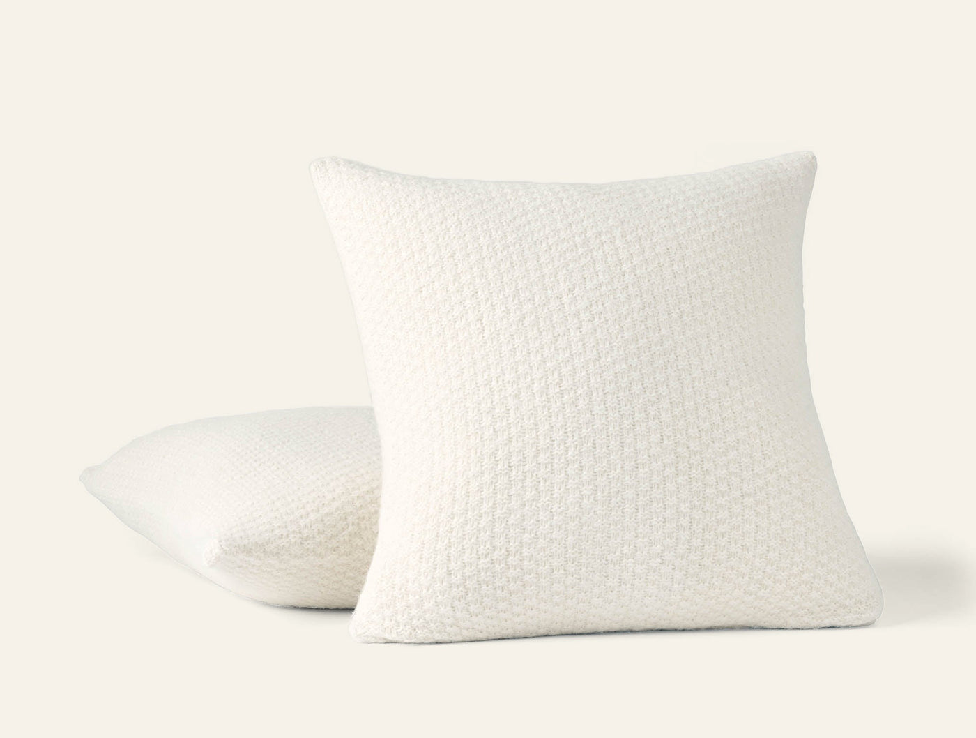 Coyuchi Cordillera ivory alpaca cotton knit pillow covers, two shown stacked at an angle.