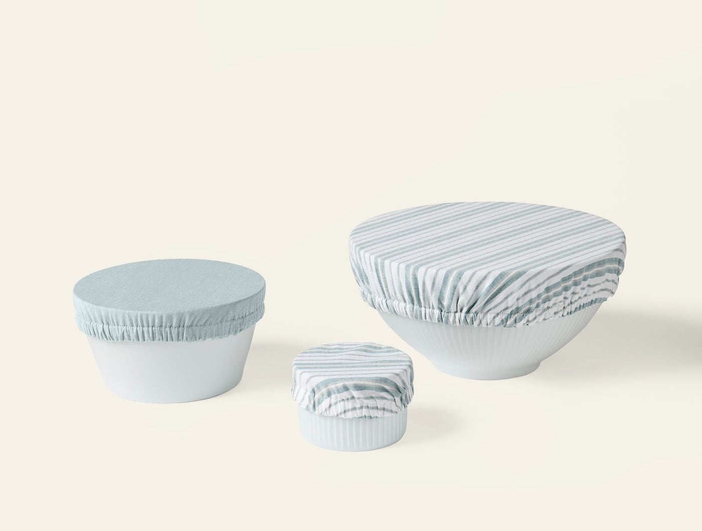 Three Coyuchi Conserve bowl covers in sage stripe, shown in small, medium, and large sizes.