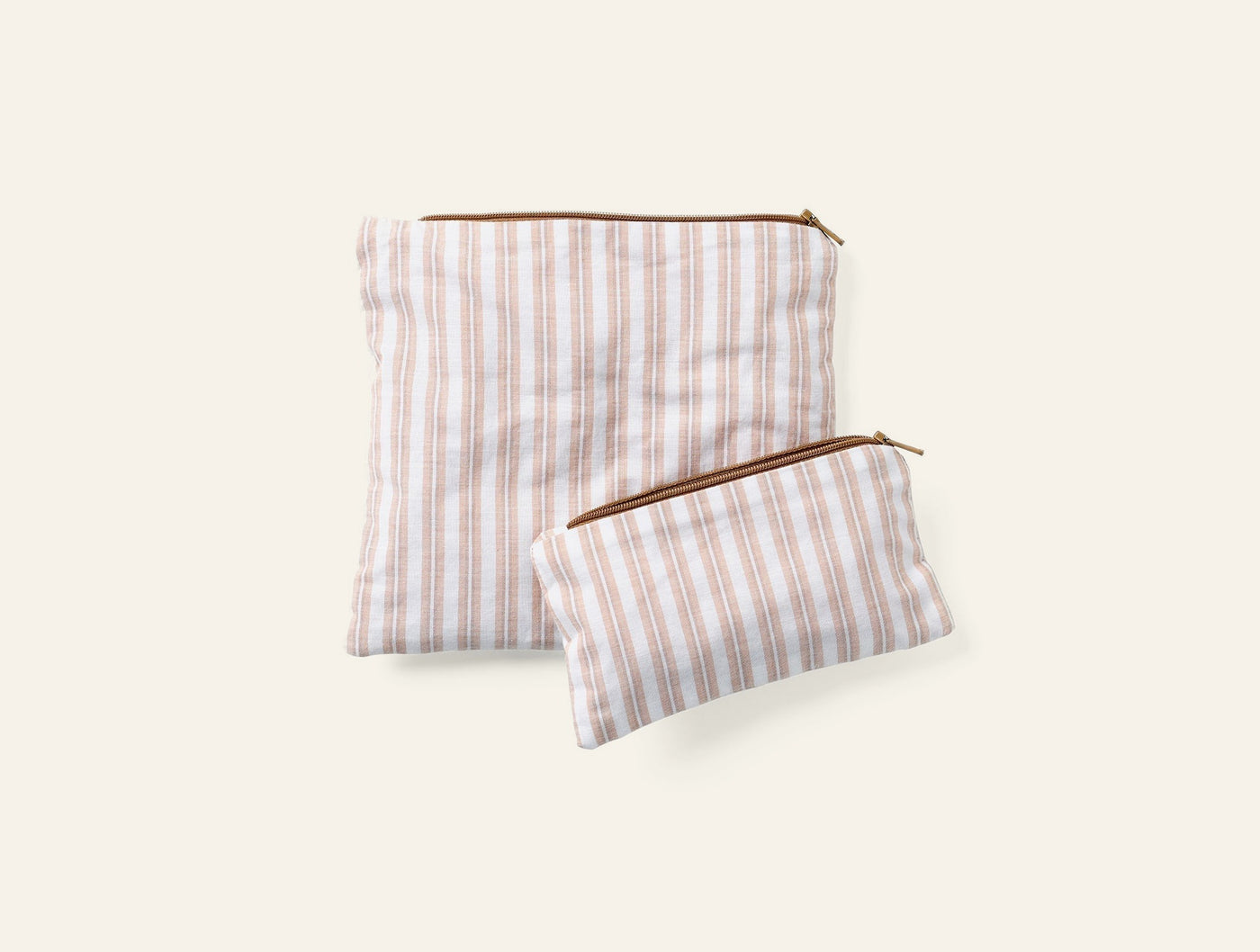 Close-up of two Coyuchi striped linen snack bags with brass zippers, large and small.