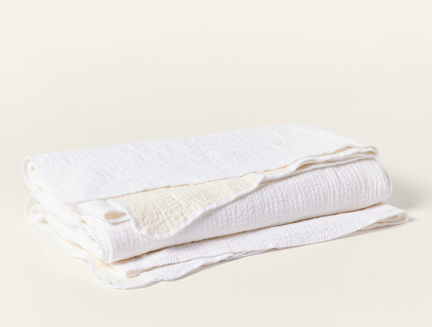Coyuchi Cozy Cotton blanket in white, folded to show crinkled muslin texture.