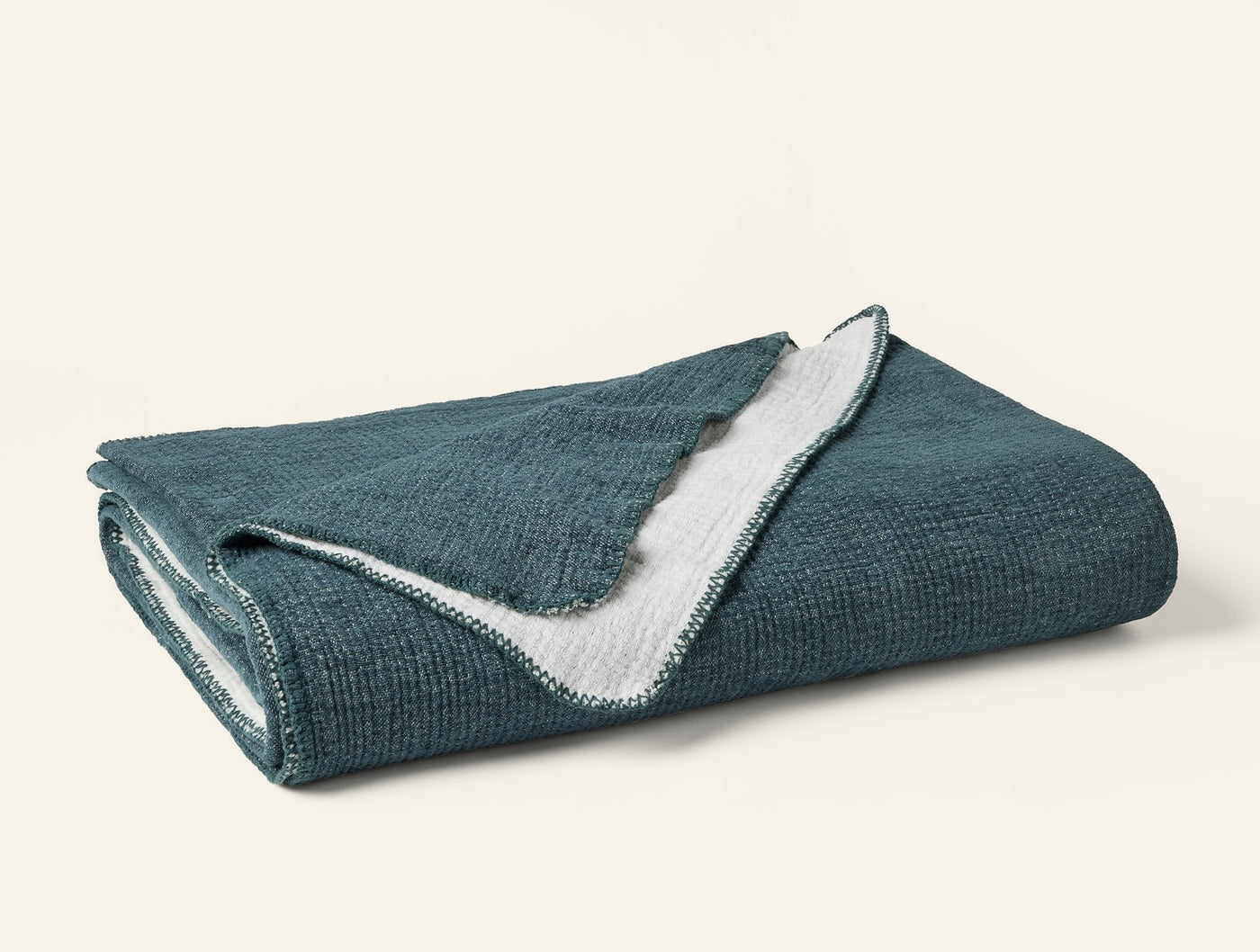 Folded teal chenille blanket with ivory reverse and crochet-style edge detail.