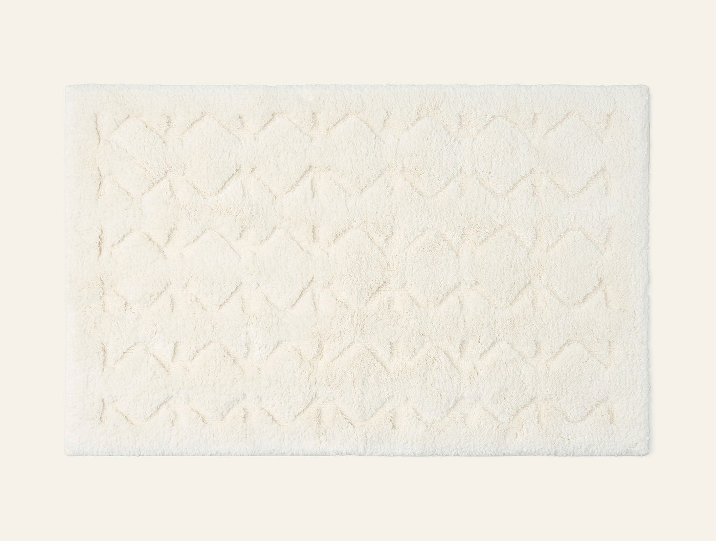 Coyuchi Diamond Shag bath rug in ivory, overhead view showing tufted diamond pattern texture.