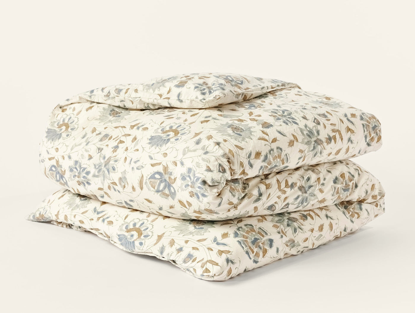 Coyuchi Flora Print duvet cover folded, ivory with sage and tan floral block print.