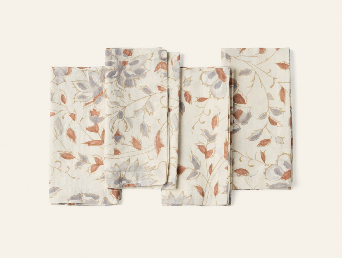 Coyuchi Flora Print napkin set in ivory with rust and grey botanical print, fanned flat lay.