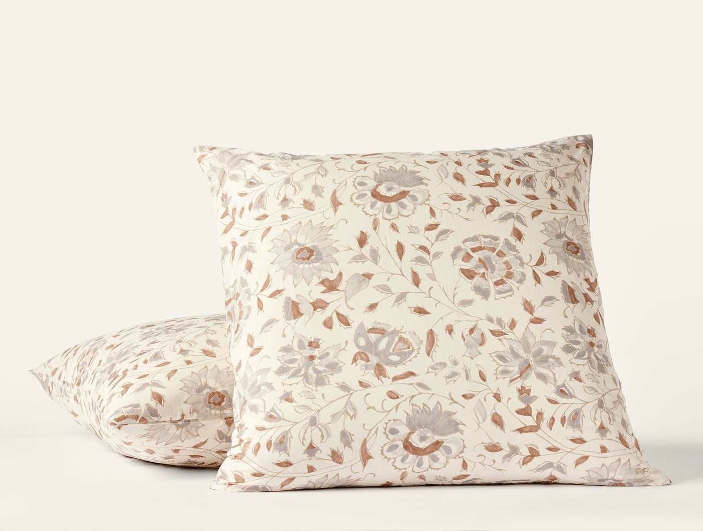 Two Coyuchi Flora Print shams in ivory with dusty rose and grey floral block-print pattern.