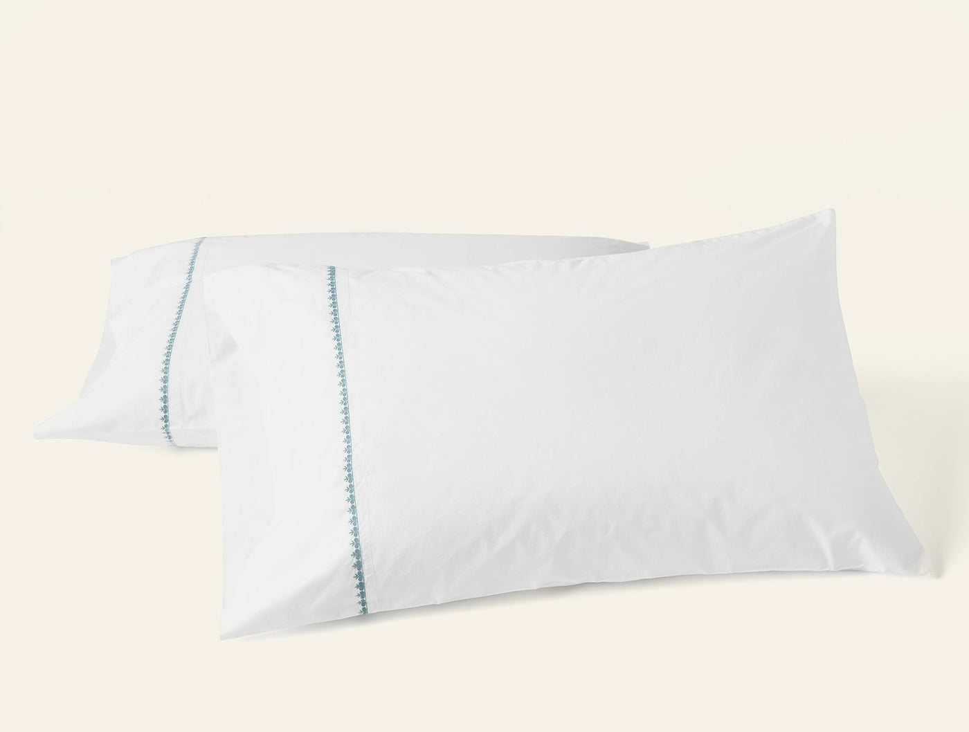 Coyuchi Floret Embroidered pillowcase pair, white with sky blue embroidered trim detail.
