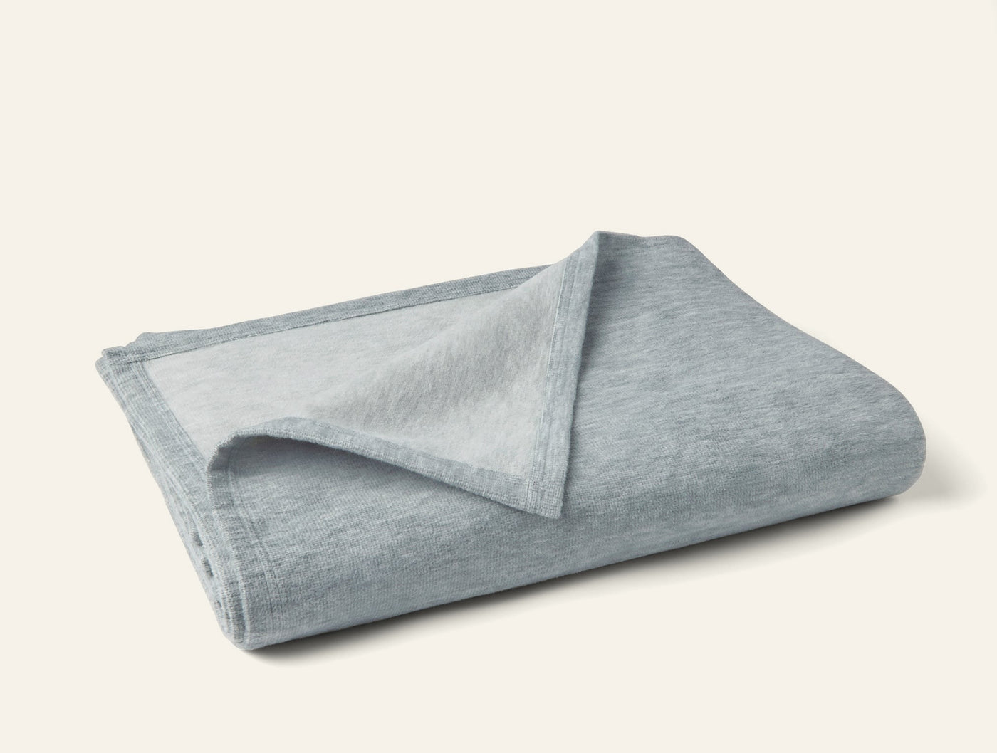 Coyuchi Full Circle Cotton blanket in mist blue, folded to show contrast reverse side.