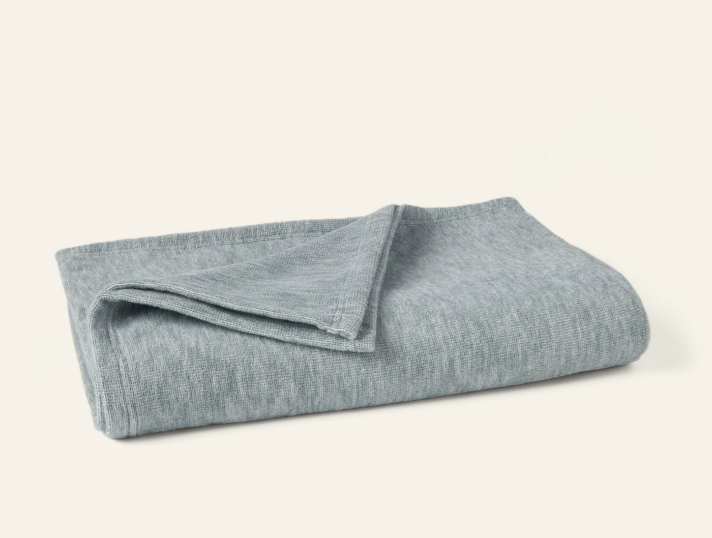 Coyuchi Full Circle Cotton throw in muted sage, folded to show soft heathered knit texture.