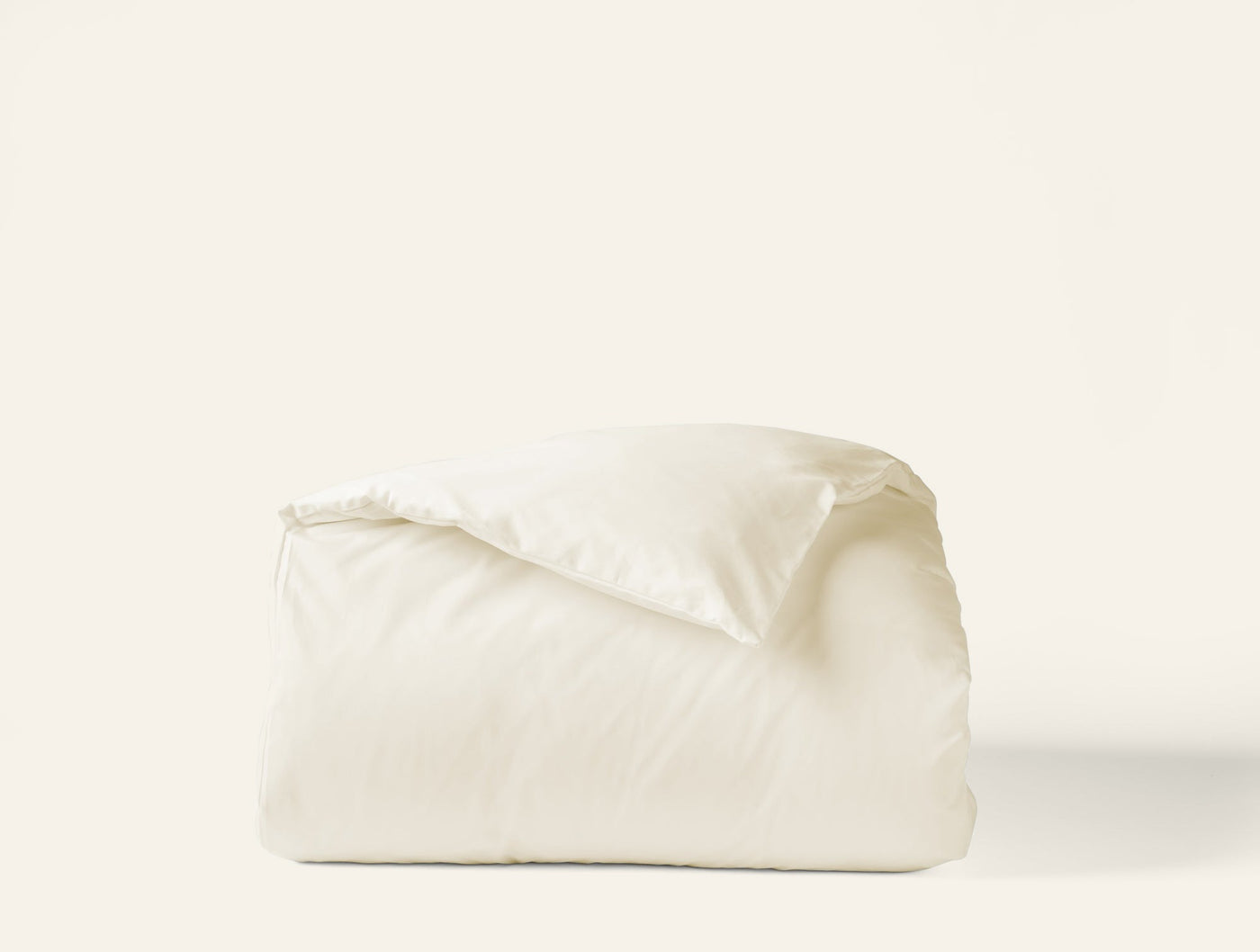 Folded ivory sateen duvet cover showing smooth lustrous finish against white background.