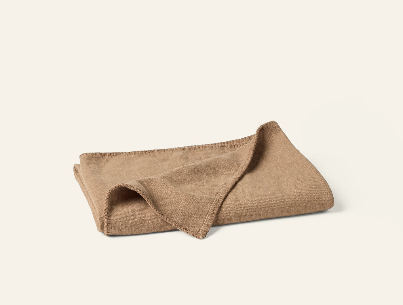 Coyuchi Helena camel linen throw, folded to show blanket stitch edge detail.