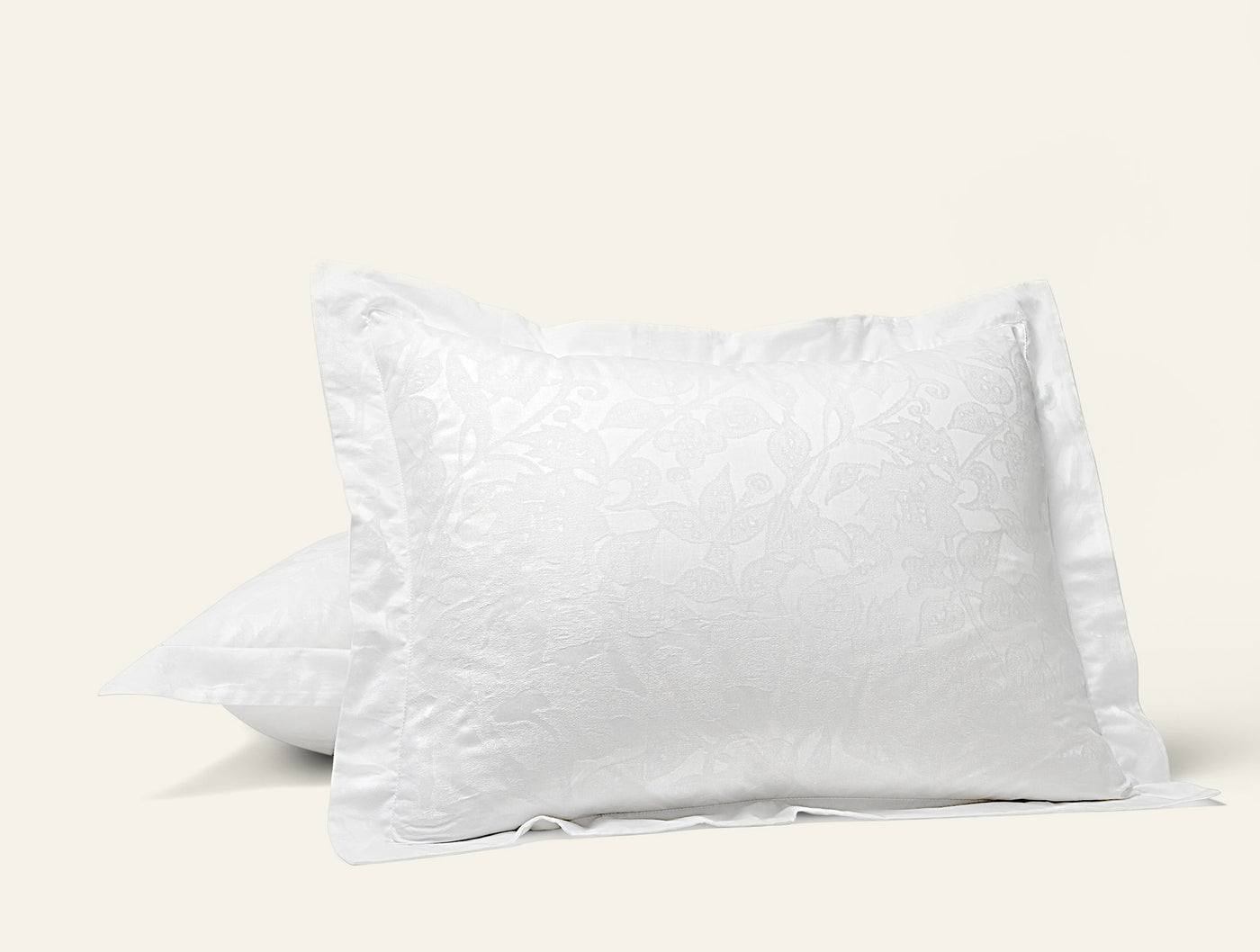 Coyuchi Heritage Percale Jacquard pillow sham in white with floral pattern.