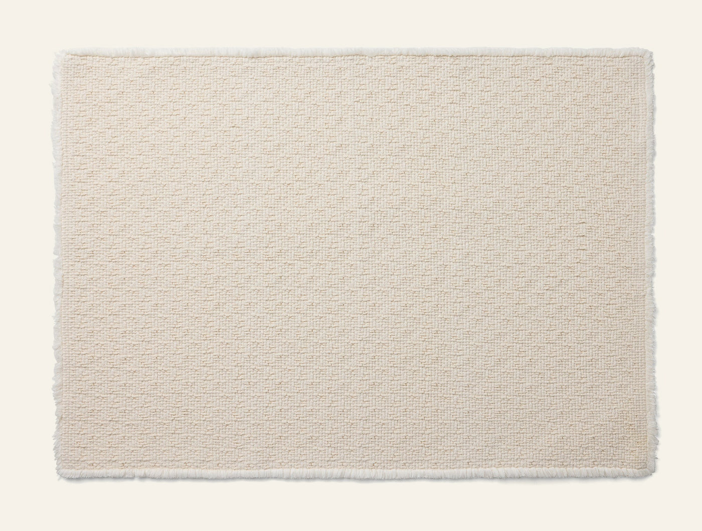 Coyuchi Honeycomb bath rug in ivory, textured honeycomb weave with fringe edges.