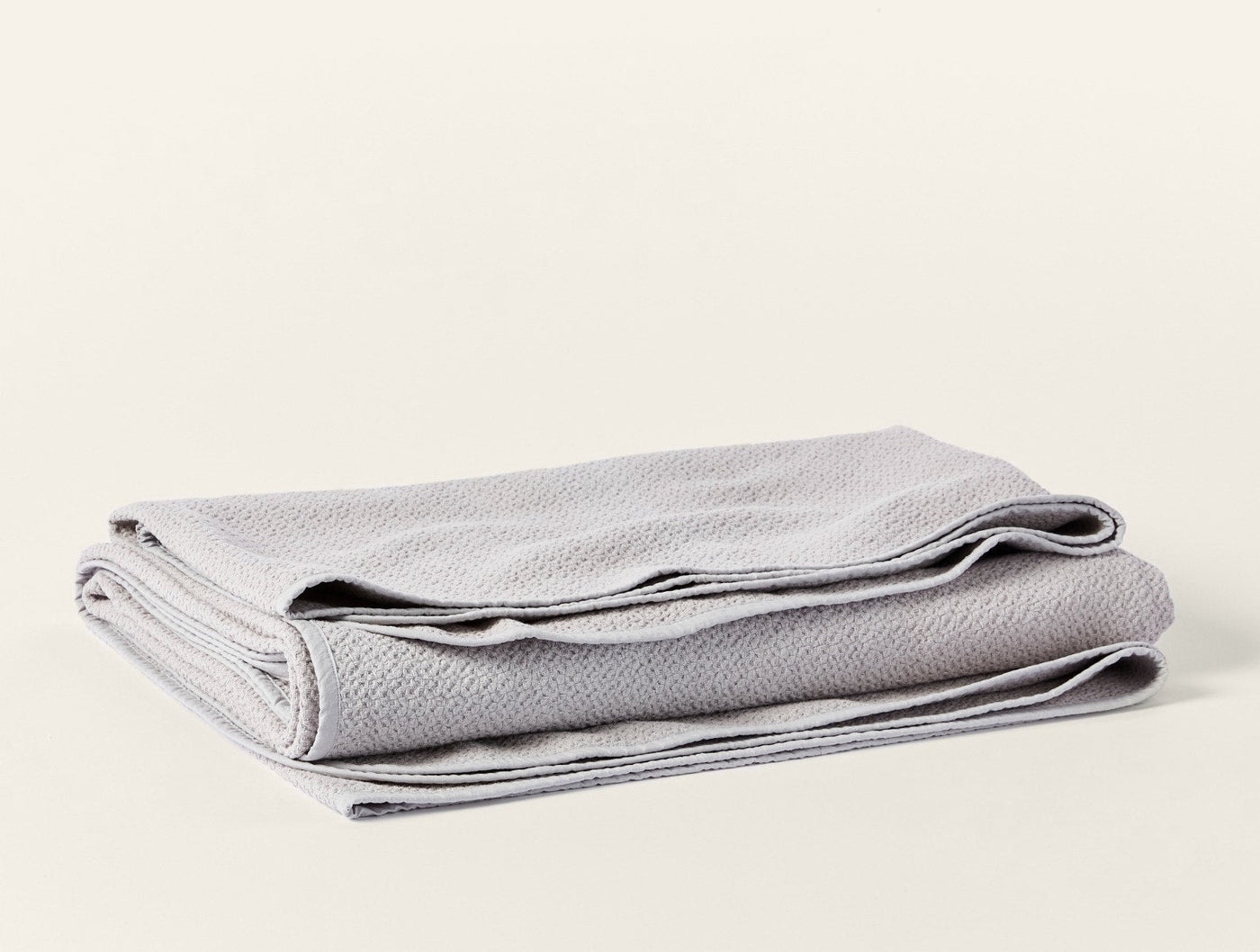 Coyuchi Honeycomb blanket folded in silver, showing textured weave and finished hem.