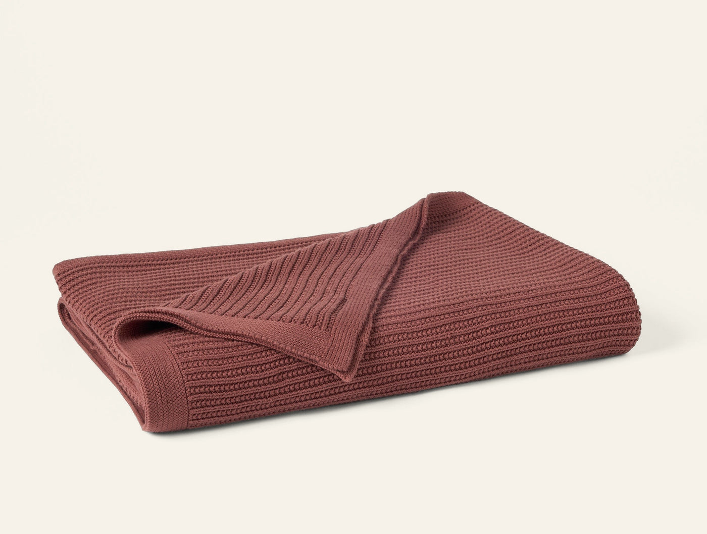 Folded dusty rose Coyuchi Linea Knit throw showing ribbed texture detail.