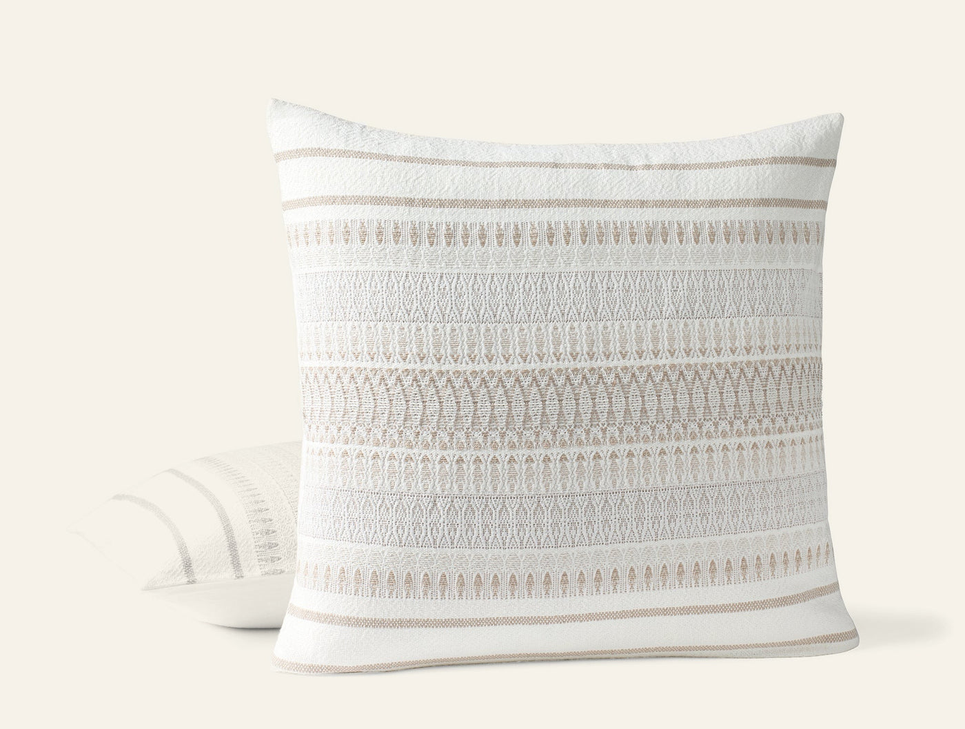 Close-up of Coyuchi Lost Coast pillow showing ivory textured stripe and fringe detail.
