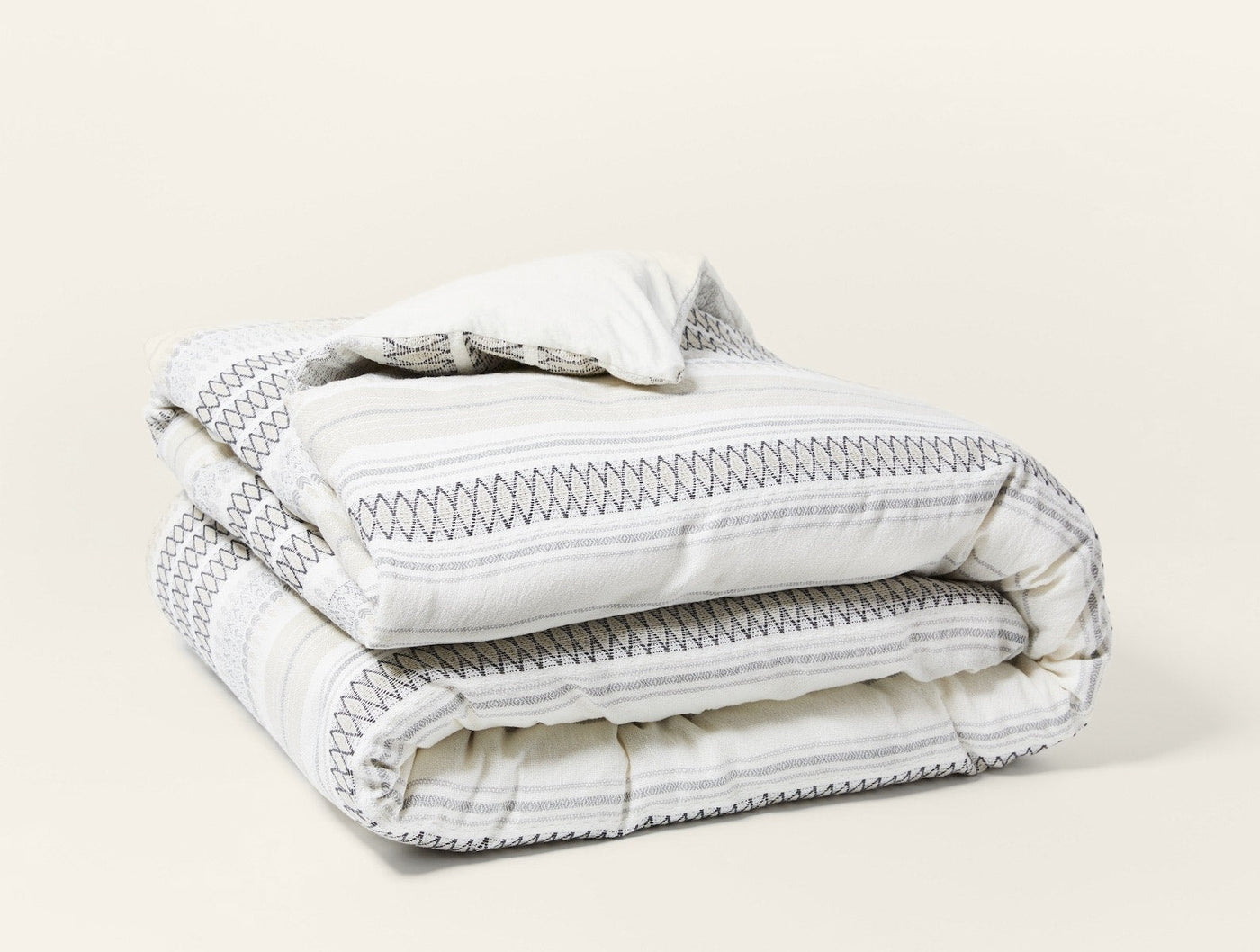 Coyuchi Lost Coast duvet cover, folded, ivory with charcoal stripe and stitch pattern.