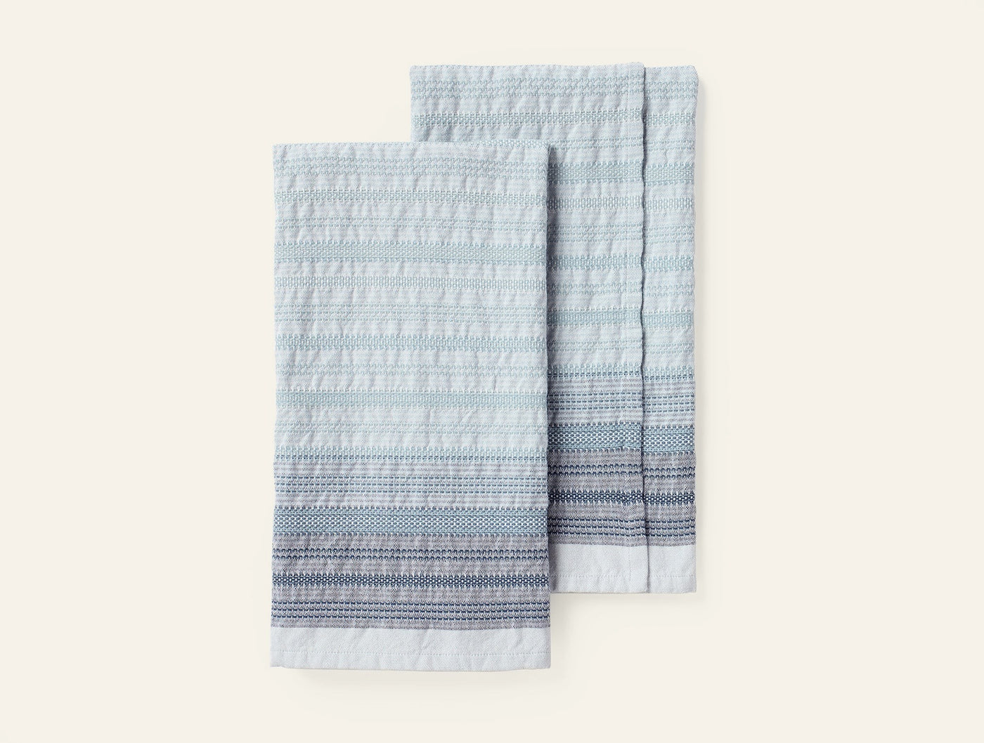 Coyuchi Magnolia hand towel pair, light blue with textured stripe border detail.