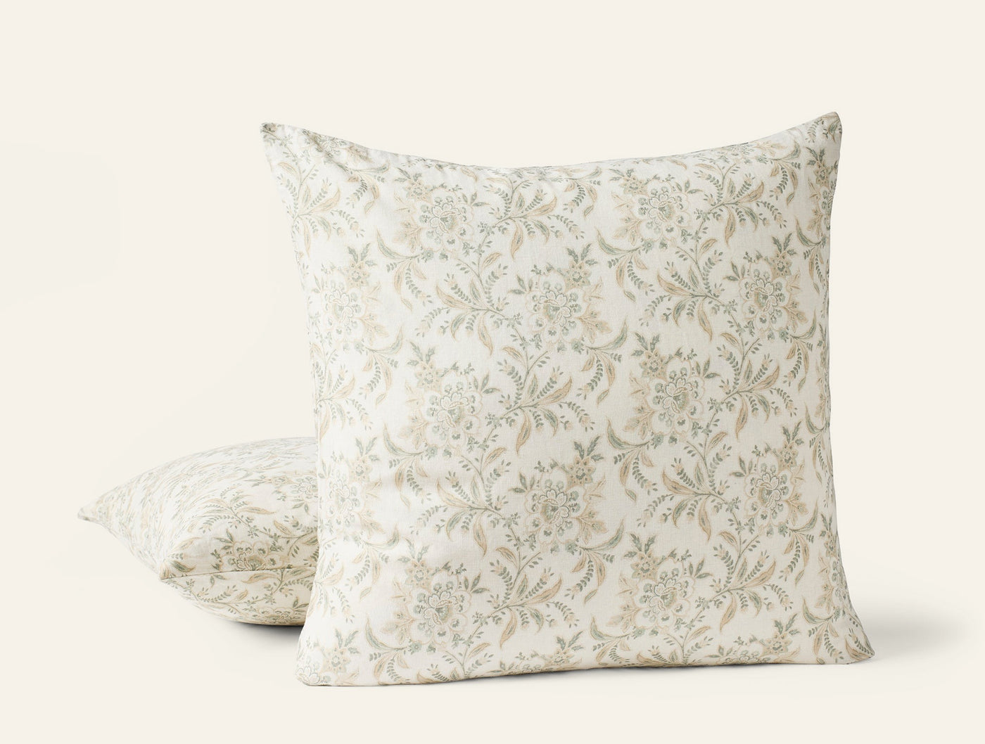 Coyuchi Marguerite Print pillow covers in ivory with sage floral vine pattern, two sizes shown.