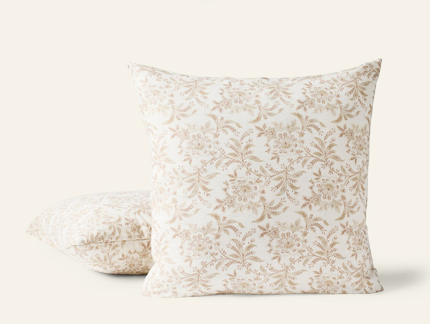 Coyuchi Marguerite Print pillow covers in ivory with tan floral print, two sizes shown.