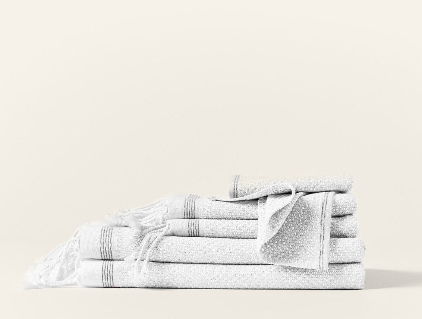 Coyuchi Mediterranean white waffle-weave guest towel set stacked with stripe trim detail.