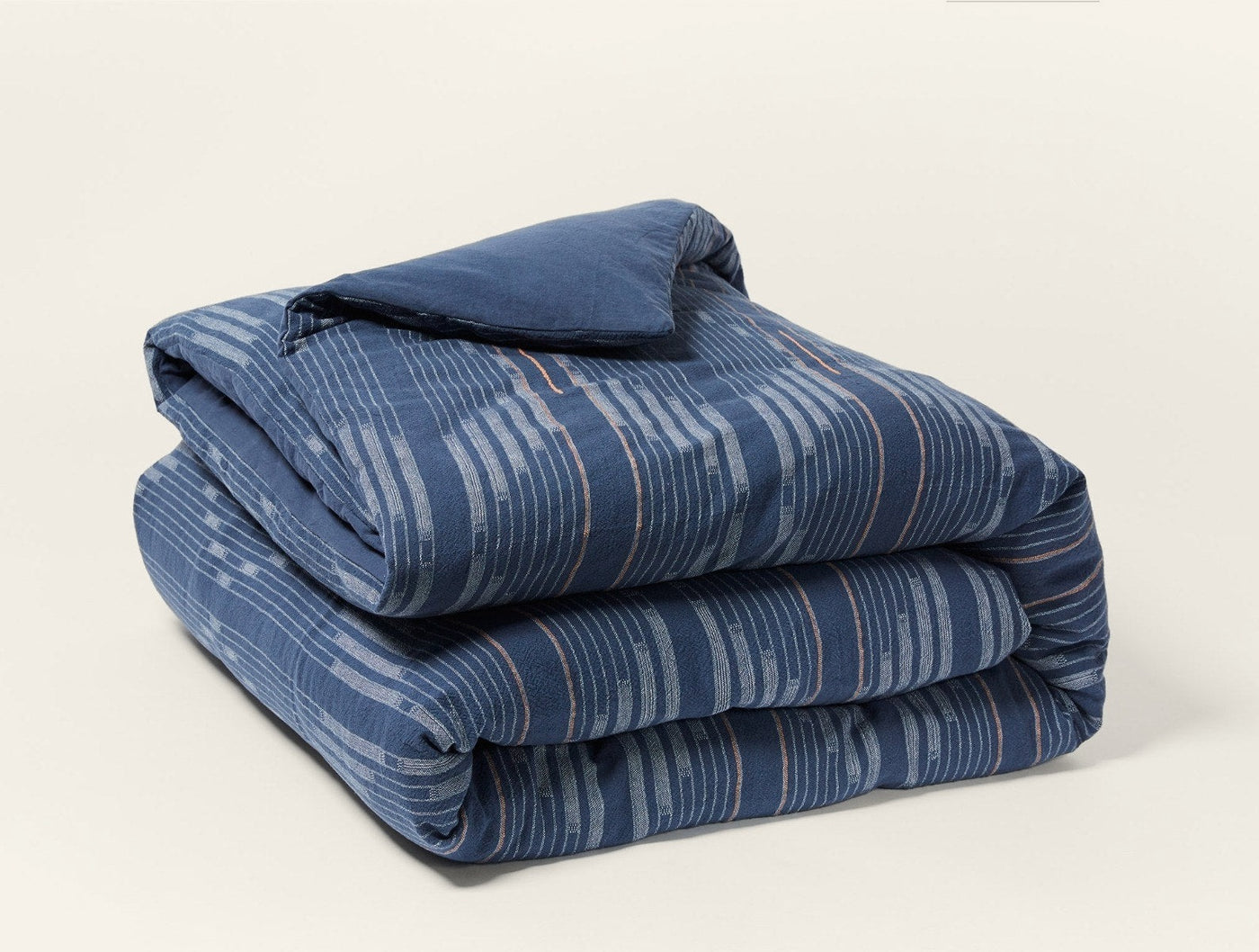 Close-up of folded Morelia duvet cover in navy with brushstroke stripe pattern.