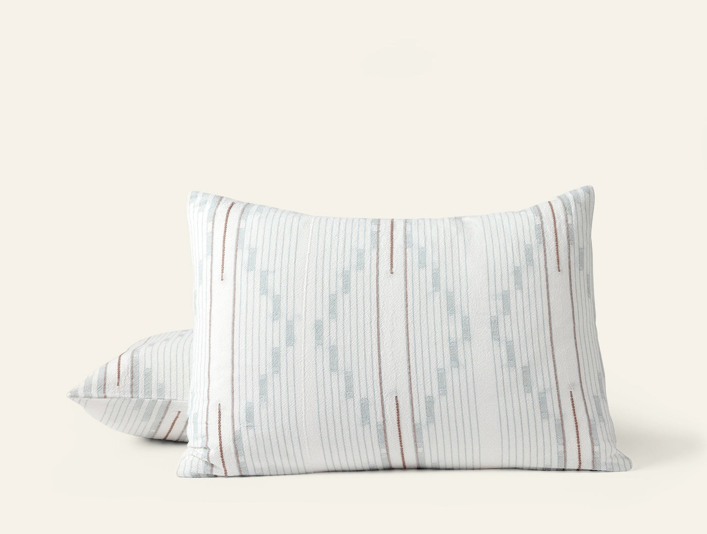 Close-up of two Morelia shams stacked, showing pale blue and rust ikat stripe pattern.
