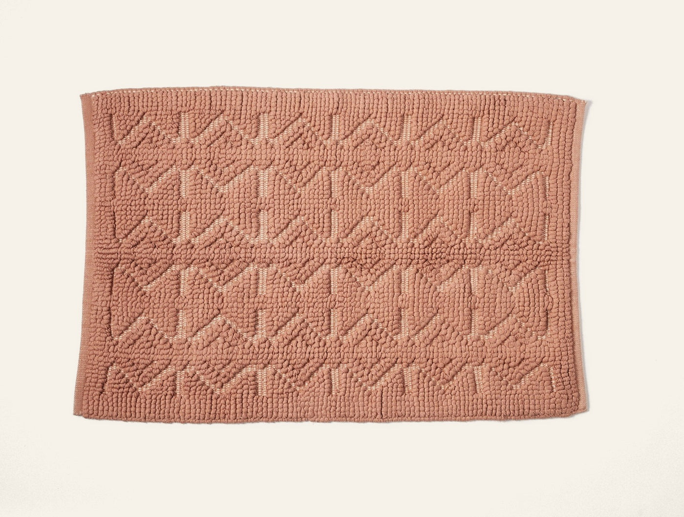 Coyuchi Mosaic Canyon bath rug in terracotta with tufted geometric pattern, flat lay.