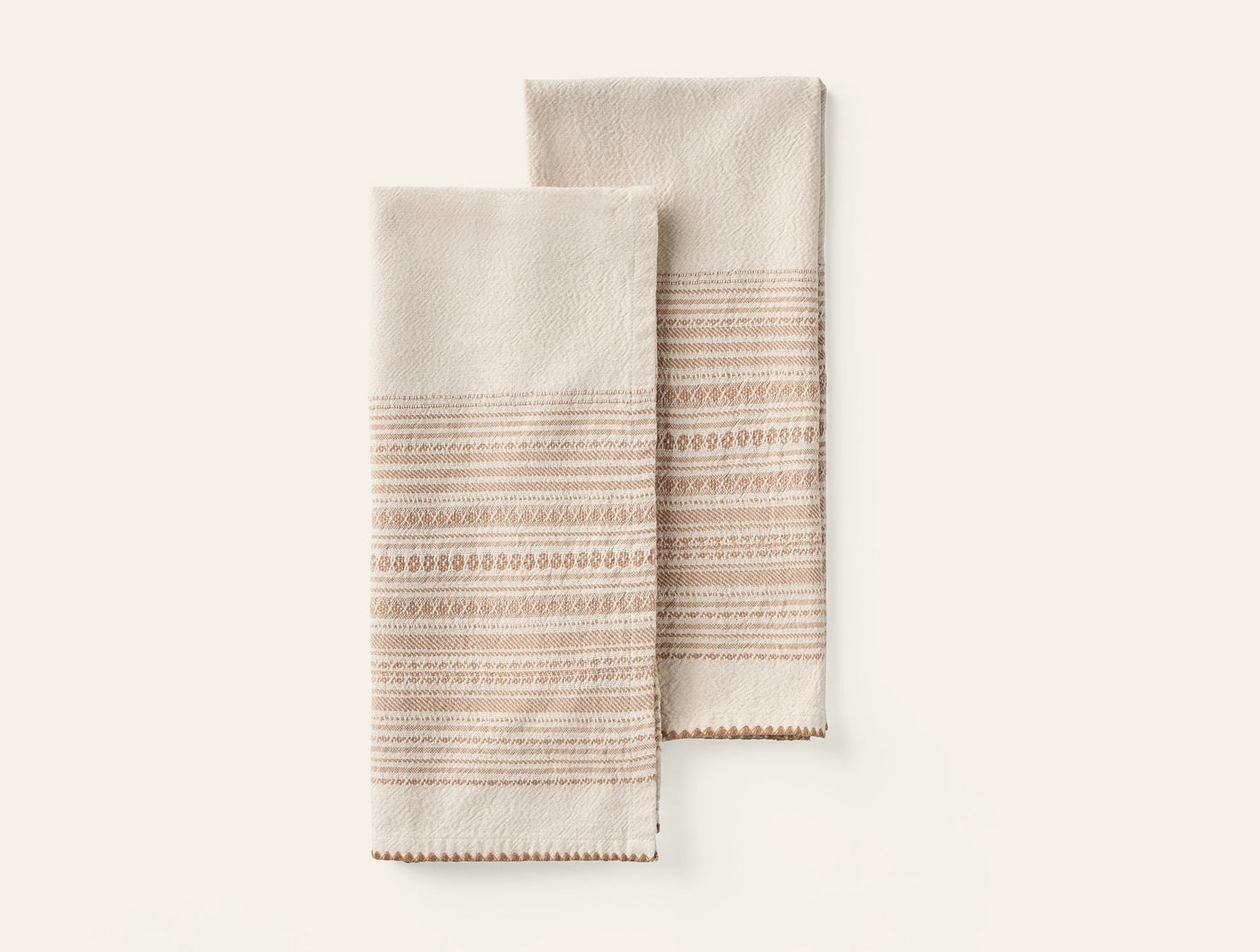Pair of Coyuchi Oak hand towels in ivory with terracotta embroidered stripe detail.
