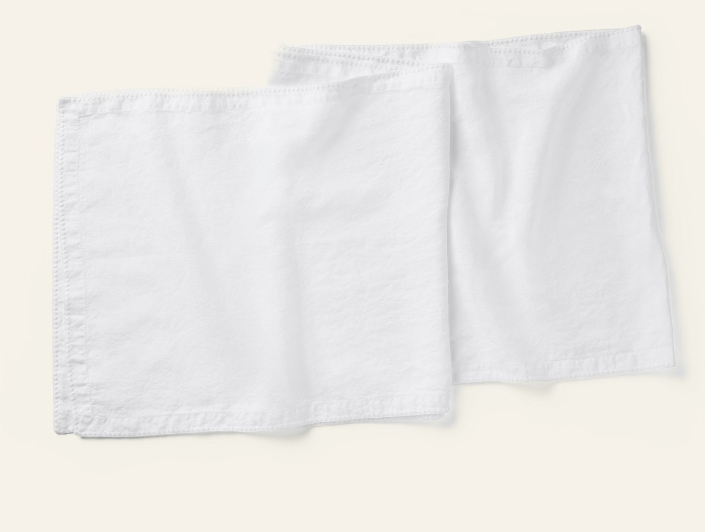 Coyuchi Olivos Embroidered Linen table runner in white, pair shown flat.
