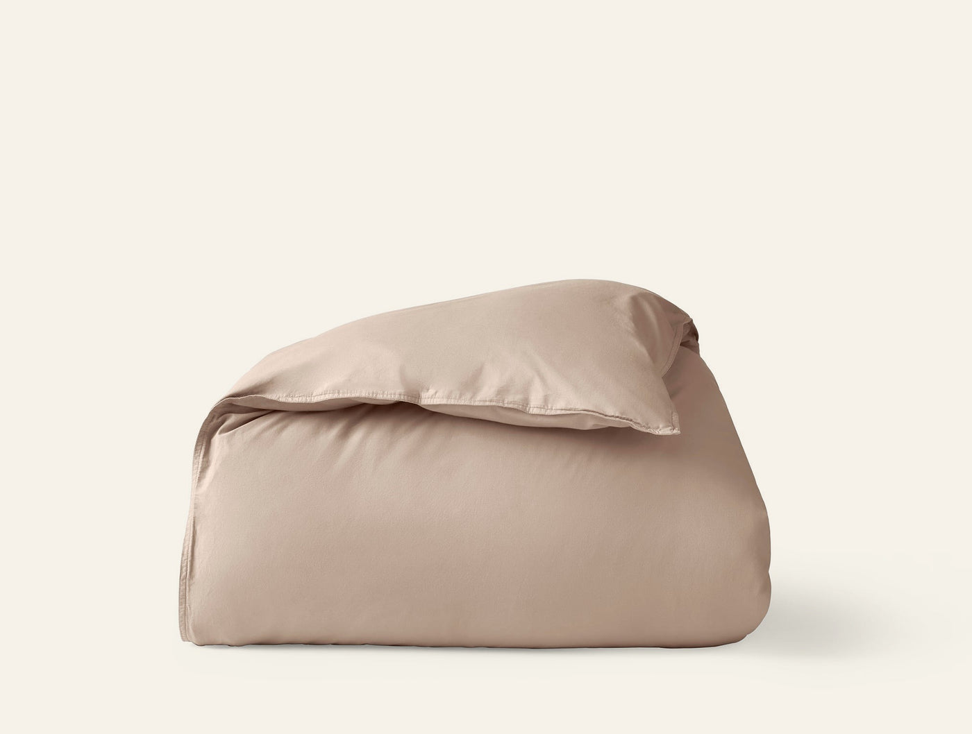 Close-up of folded Coyuchi Crinkled Percale duvet cover in warm taupe against white background.