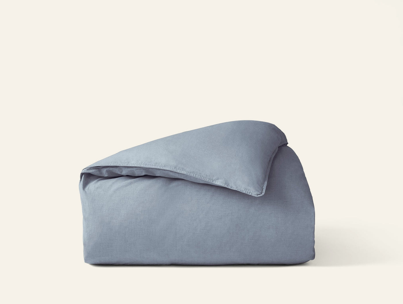 Close-up of folded Coyuchi Crinkled Percale duvet cover in slate blue with relaxed texture.