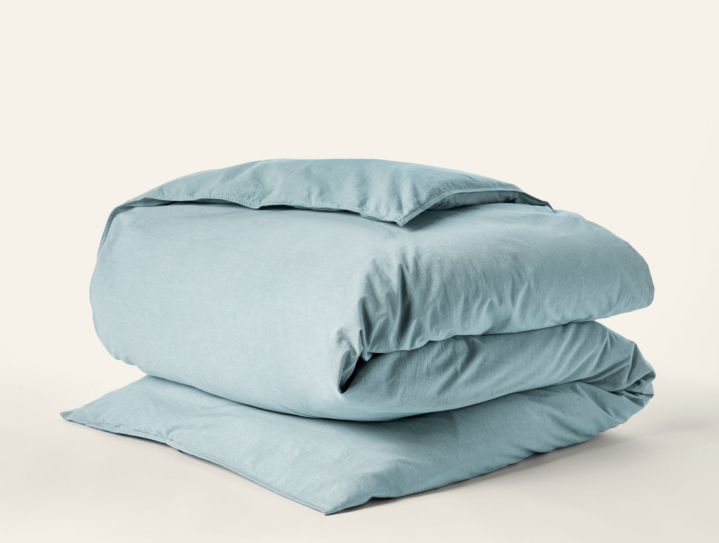 Coyuchi Crinkled Percale duvet cover folded, shown in muted aqua with relaxed texture.