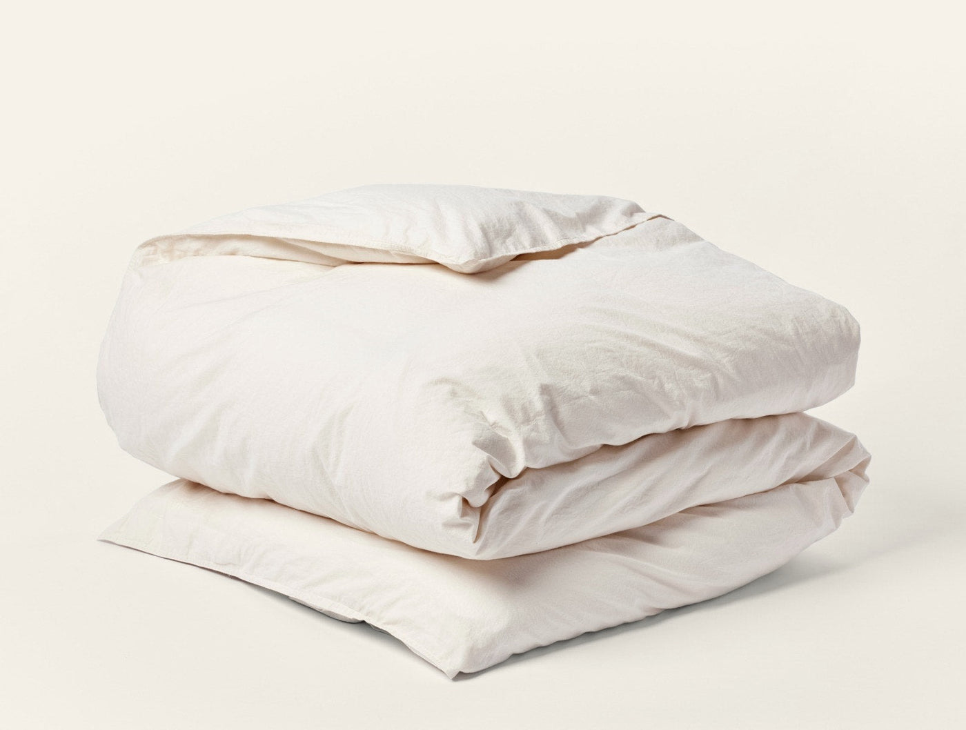Ivory crinkled percale duvet cover folded against a white background.