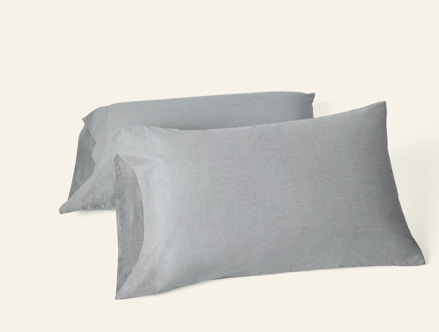 Two slate grey crinkled percale pillowcases stacked at an angle on white background.