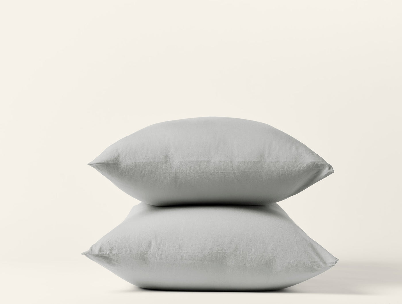 Two stacked Coyuchi Crinkled Percale pillowcases in silver grey against white background.