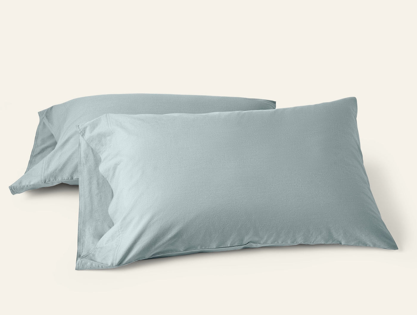 Two Coyuchi Crinkled Percale pillowcases in mist blue, soft textured finish, pair stacked.