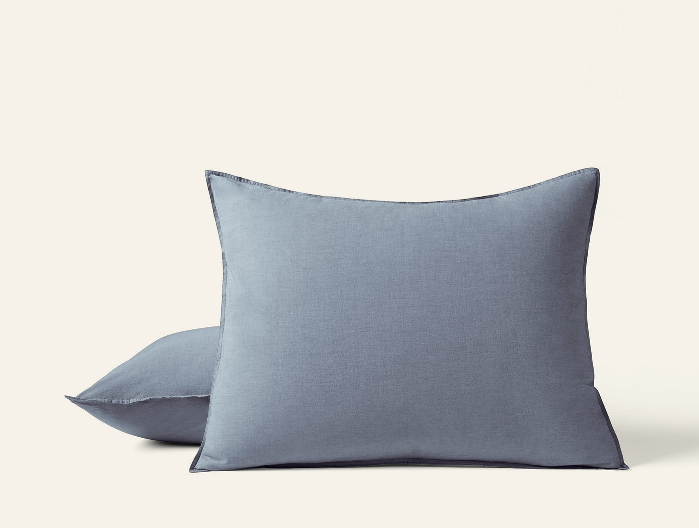 Two stacked Coyuchi Crinkled Percale shams in slate blue with subtle texture detail.