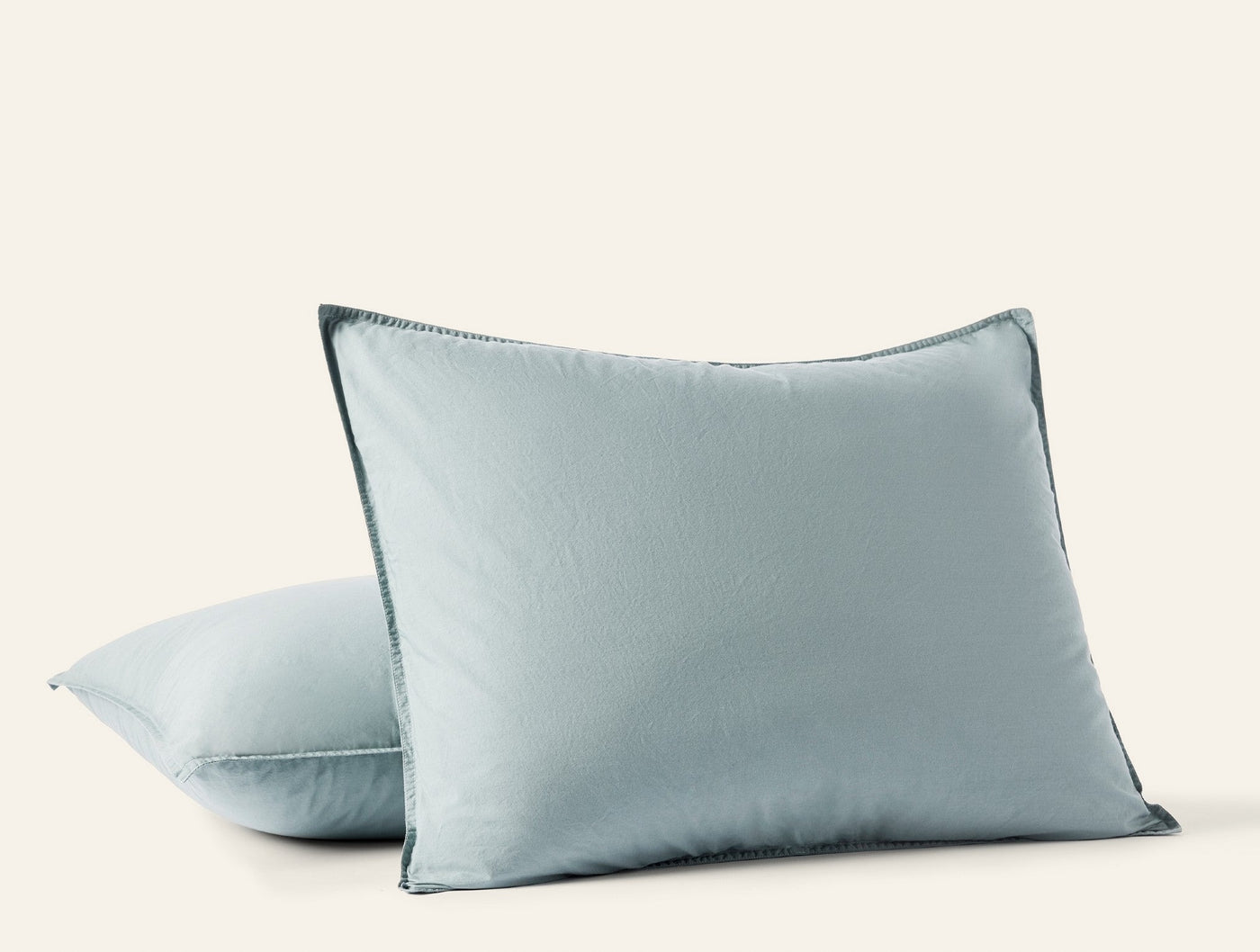 Two stacked seafoam Coyuchi Crinkled Percale shams showing blanket-stitch edge detail.
