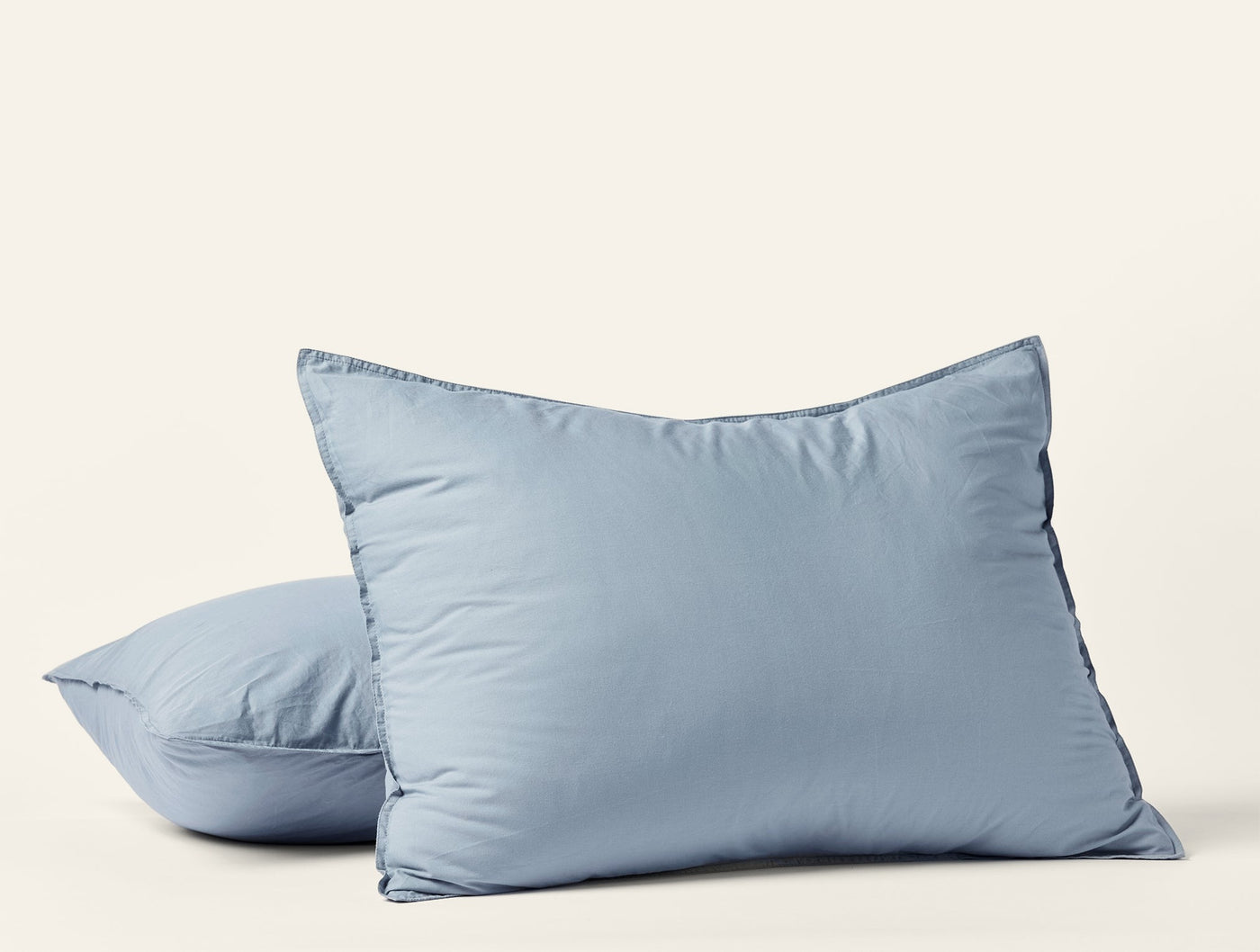 Two slate blue Coyuchi Crinkled Percale shams stacked, showing relaxed texture and flange edge.